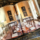 Modern English Interiors by todhunter earle book showing a huge dining hall with ancestral portraits on the walls