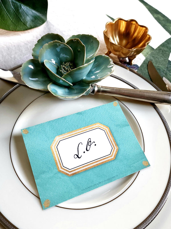 The Punctilious Mr. P's place card co. 'Envoy- Jardin' shades of greens laydown event size custom place cards on printed tablecloth tablescape with fresh flowers and vintage silver cutlery