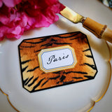 Close-up of a tiger-print place card, a guest's name in script inside its gold-framed cartouche