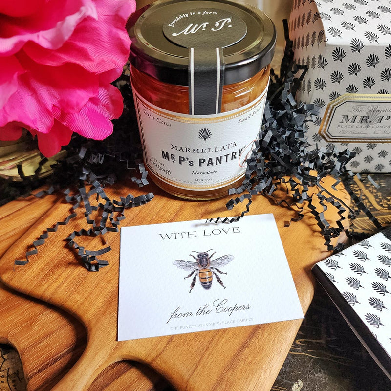 The Punctilious Mr. P's Place Card Co. "Bees" Custom Gift Notes on a chinoiserie table with marmalade jam, cutting board and fresh flowers