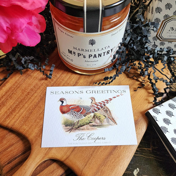 The Punctilious Mr. P's Place Card Co. "Pheasantry" Custom Gift Notes on a chinoiserie table with marmalade jam, cutting board and fresh flowers