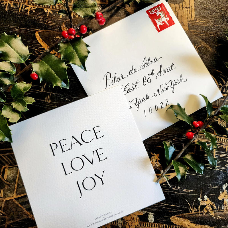 The Punctilious Mr. p's place card co. collab with sarah v battle showing back of holiday card that reads: peace, love, joy