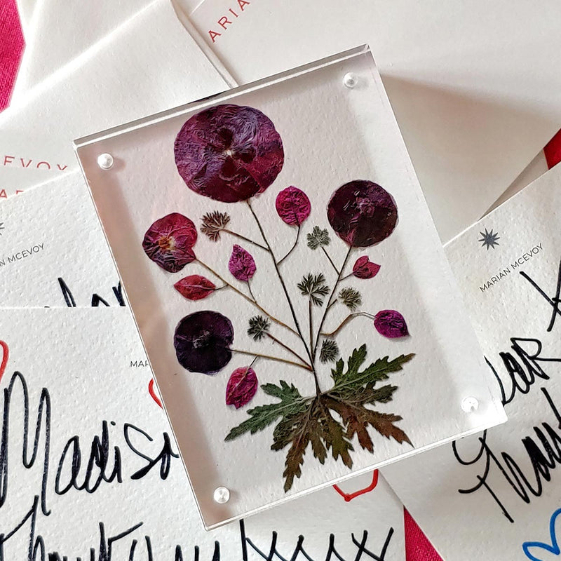 Marian McEvoy x The Punctilious Mr. P's Place Card Co collab with close up of purple pressed poppy botanical motif magnetic acrylic paperweight