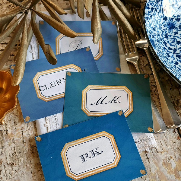 showing all 4 of The Punctilious Mr. P's place card co. 'Envoy- Marine' shades of blues laydown event size custom place cards on printed tablecloth tablescape with fresh flowers and vintage silver cutlery