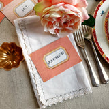 The Punctilious Mr. P's place card co. 'Envoy- Marine' shades of oranges laydown event size custom place cards on printed tablecloth tablescape with fresh flowers and vintage silver cutlery