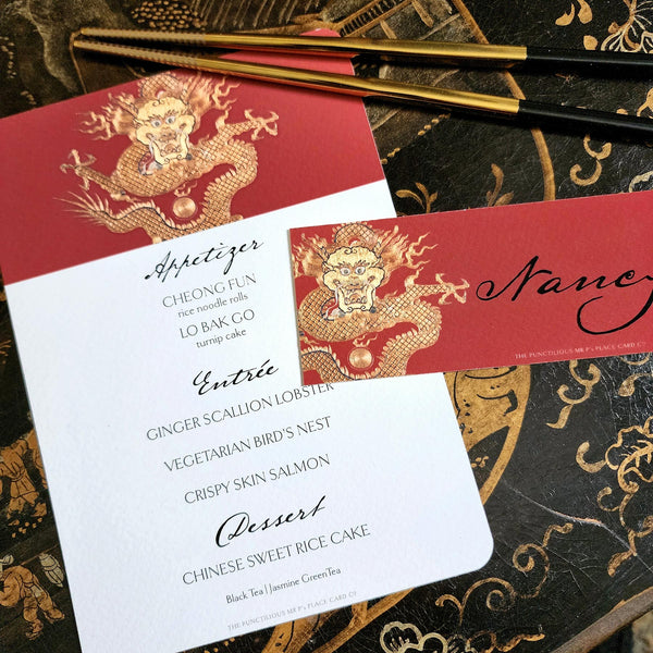 The Punctilious Mr. P's Place Card Co. "Radiant Dragon" menu card featuring a golden-hue dragon on a chinoiserie set of china with golden chop sticks