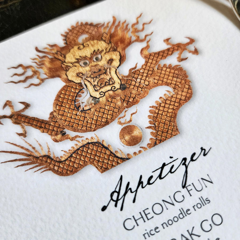 detail of The Punctilious Mr. P's Place Card Co. "Radiant Dragon" menu card featuring a golden-hue dragon