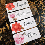 showing all 4 of The Punctilious Mr. P's place card co. 'Blossoms' laydown size custom place cards on black and gold china tablescape with fresh flowers and vintage silver cutlery