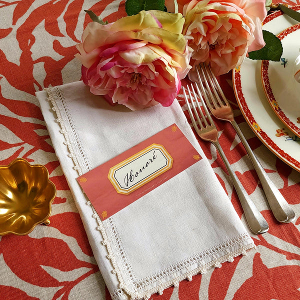 The Punctilious Mr. P's place card co. 'Envoy- Brique' shaded of reds laydown size custom place cards on printed tablecloth tablescape with fresh flowers and vintage silver cutlery
