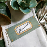 The Punctilious Mr. P's place card co. 'Envoy- Jardin' shades of greens laydown size custom place cards on printed tablecloth tablescape with fresh flowers and vintage silver cutlery