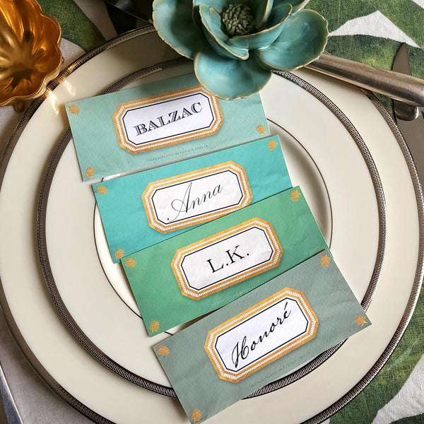 showing all 4 hues of The Punctilious Mr. P's place card co. 'Envoy- Jardin' shaded of greens laydown size custom place cards on printed tablecloth tablescape with fresh flowers and vintage silver cutlery