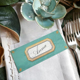 The Punctilious Mr. P's place card co. 'Envoy- Jardin' shades of greens laydown size custom place cards on printed tablecloth tablescape with fresh flowers and vintage silver cutlery