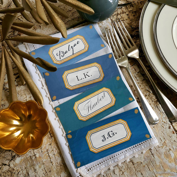 showing all 4 hues of The Punctilious Mr. P's place card co. 'Envoy- Marine' shades of blues laydown size custom place cards on printed tablecloth tablescape with fresh flowers and vintage silver cutlery