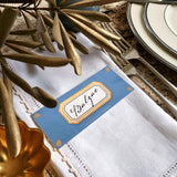 The Punctilious Mr. P's place card co. 'Envoy- Marine' shades of blues laydown size custom place cards on printed tablecloth tablescape with fresh flowers and vintage silver cutlery