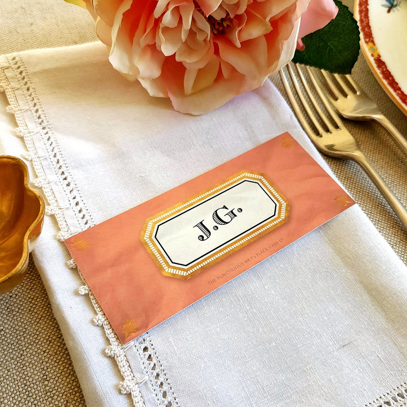 The Punctilious Mr. P's place card co. 'Envoy- Melon' shades of oranges laydown size custom place cards on printed tablecloth tablescape with fresh flowers and vintage silver cutlery