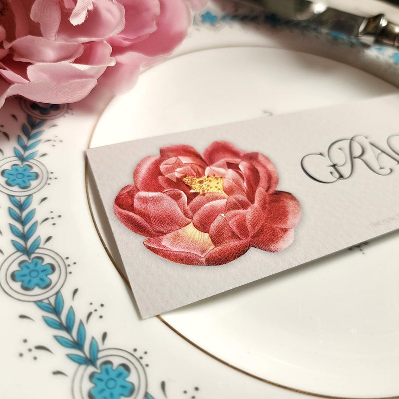 detail of The Punctilious Mr. P's place card co. 'Peony' laydown size custom place cards on black and gold china tablescape with fresh flowers and vintage silver cutlery