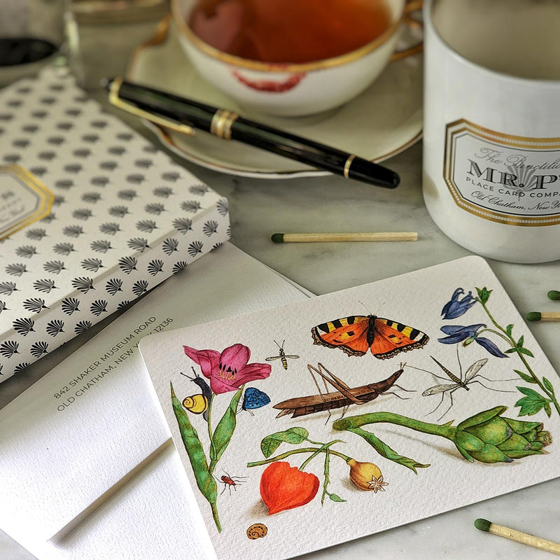 The punctilious mr. p's place card co. 'Garden Variety' illustrated custom note card theme with the iconic black and white anthemion folio packaging with tea cup and montblanc fountain pen