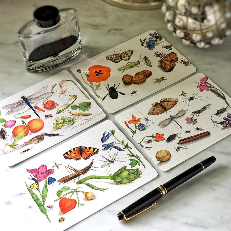 showing all 4 designs in the set of The punctilious mr. p's place card co. 'Garden Variety' illustrated custom note card theme with the iconic black and white anthemion folio packaging with montblanc fountain pen
