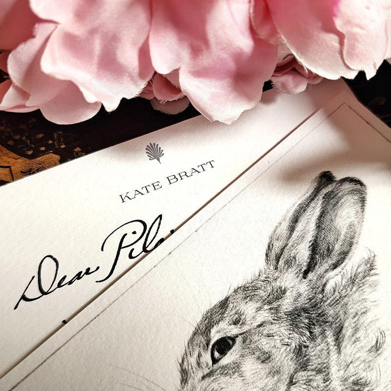 The Punctilious Mr. P's Place Card Co. 'BUNNY' custom note card pack with a montblanc fountain pen on a chinoiserie table with cup of tea and large beautiful peony flower