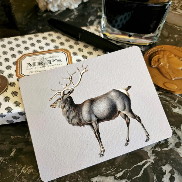 The Punctilious Mr. P's Place Card Co. 'Elk' custom note card pack on a black marble table with signature anthemion note card box and fountain pen and bronze medallion in the background