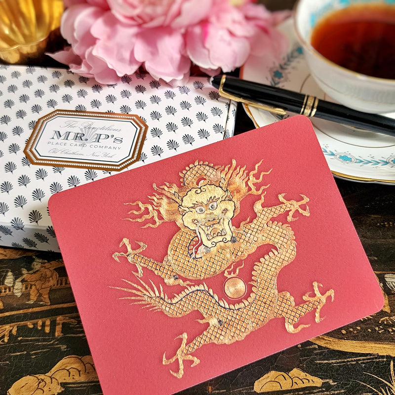 The Punctilious Mr. P's Place Card Co. 'Radiant Dragon-Cinnabar' custom note card pack with a montblanc fountain pen on a chinoiserie table with cup of tea and large beautiful peony flower
