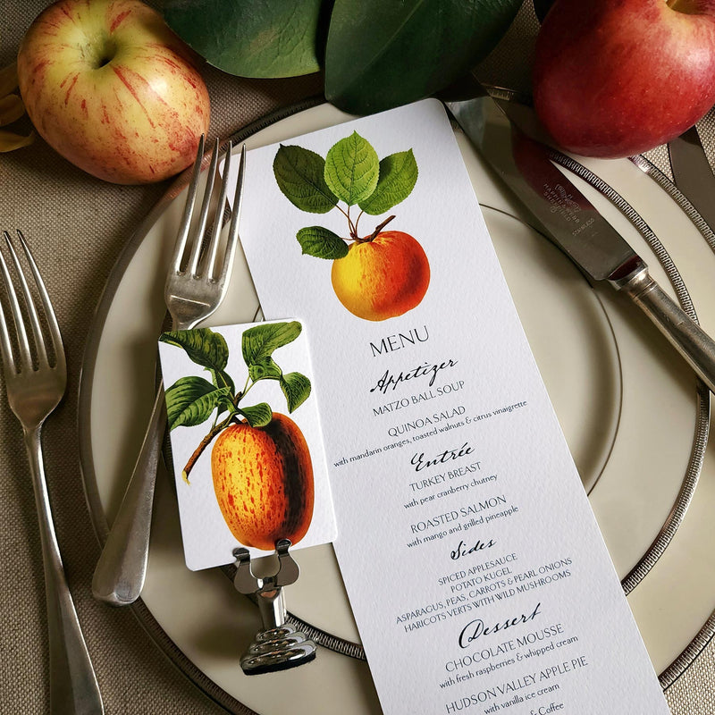 The Punctilious Mr. P's Place Card Co. "Apple Medley" menu card on simple white china decorated with magnolia leaves, real apples and vintage cutlery