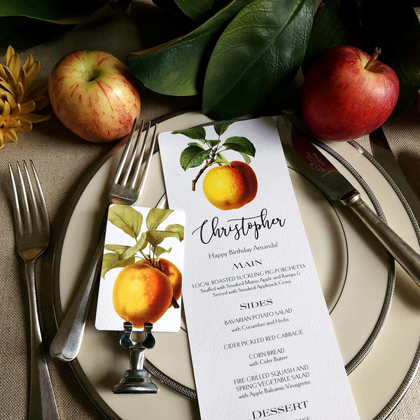 The Punctilious Mr. P's Place Card Co. "Apple Medley" menu card on simple white china decorated with magnolia leaves, real apples and vintage cutlery