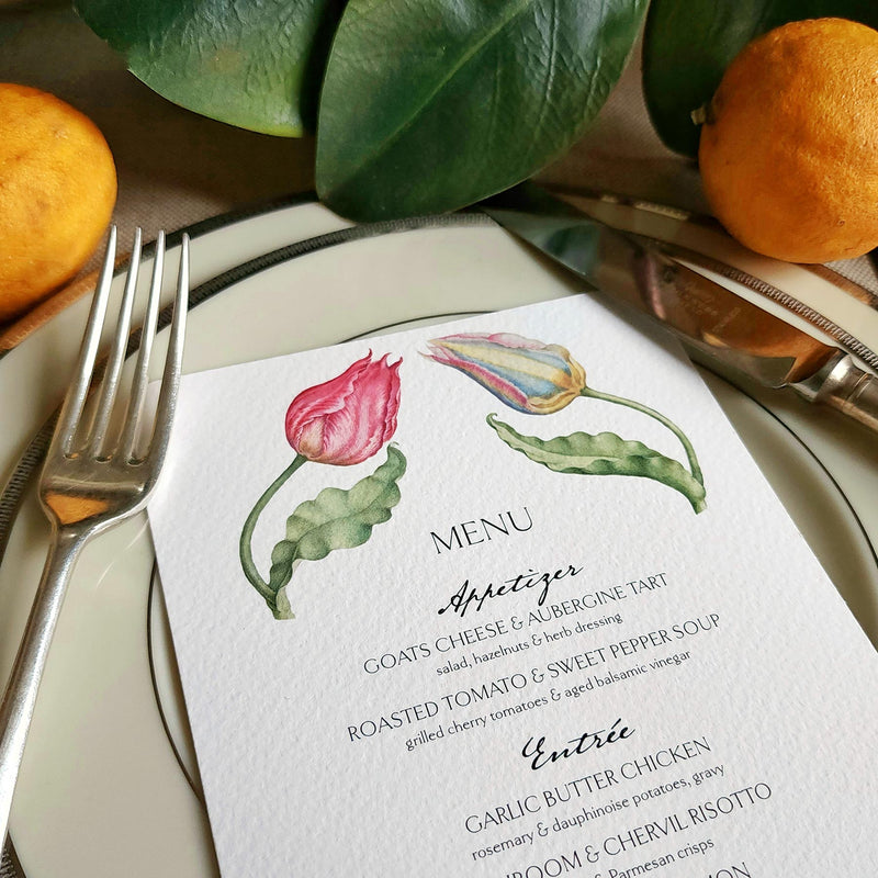 The Punctilious Mr. P's Place Card Co. "Parrot Tulips" menu card on simple white china decorated with magnolia leaves, real oranges and vintage cutlery
