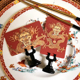close up of The Punctilious Mr. P's Place Card Co. 'Radiant Dragon-Cinnabar' Custom Place Cards on a chinoiserie table