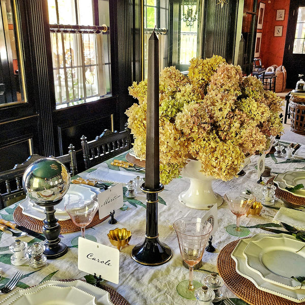 a stunning tablescape by the punctilious mr. p's place card co featuring a tall black taper candle with a dried hydrangea centerpiece and place cards on the table
