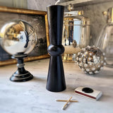 tall pillar candles on white marble table with a stainless steel orb and base and a small box of matches