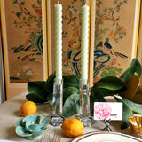 featuring The Punctilious Mr. P's Place Card Co. rope taper candle in celadon on a simple tablescape with large magnolia leaves, place card, ceramic flowers against a chinoiserie screen as a backdrop