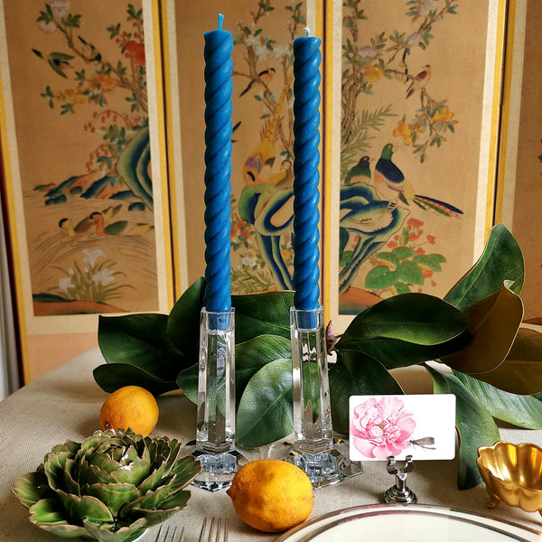 featuring The Punctilious Mr. P's Place Card Co. rope taper candle in peacock on a simple tablescape with large magnolia leaves, place card, ceramic flowers against a chinoiserie screen as a backdrop