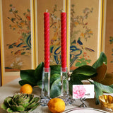 featuring The Punctilious Mr. P's Place Card Co. rope taper candle in red on a simple tablescape with large magnolia leaves, place card, ceramic flowers against a chinoiserie screen as a backdrop