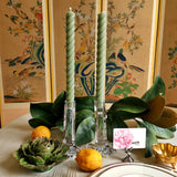 featuring The Punctilious Mr. P's Place Card Co. rope taper candle in sage on a simple tablescape with large magnolia leaves, place card, ceramic flowers against a chinoiserie screen as a backdrop