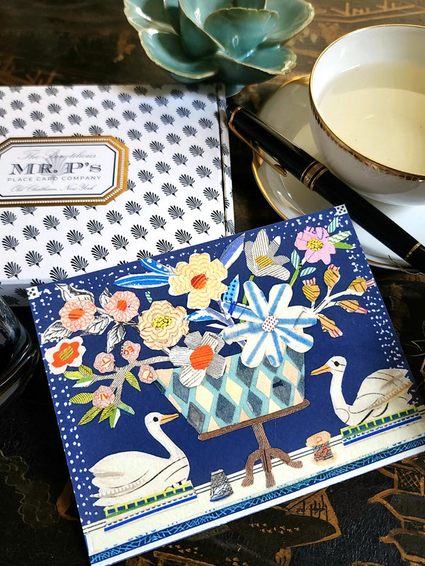 The Punctilious Mr. P's Place Card Co. X Sarah V Battle collaboration featuring "the swan" from "The Doves and Swans" fine note card set on a chinoiserie table with a cup of tea, montblanc fountain pen and our signature black and white anthemion pattern box