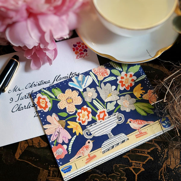 The Punctilious Mr. P x Sarah V Battle "Red Birds" fine note card set featuring collage reproductions of her original artwork, on chinoiserie table with Mr. P's I conic black and white anthemion print. montblanc fountain pen resting by