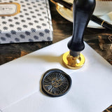 The Punctilious Mr. P's Place Card Co. x Sarah V Battle sun face wax seal on the back of an envelope