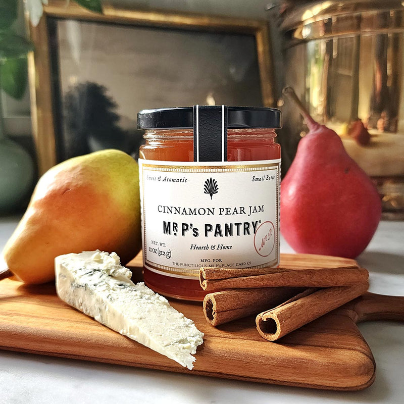 Mr. P's Pantry "cinnamon Pear Jam" on a teak cutting board with ripe pears and cinnamon sticks in the background