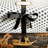 detail of bow on Mr. P's Pantry's Jam Trio Gift Set packaging wrapped in signature anthemion pattern with gold foil label and black grosgrain ribbon
