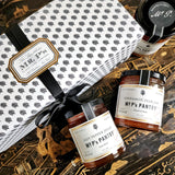 Mr. P's Pantry's Jam Trio Gift Set packaging wrapped in signature anthemion pattern with gold foil label and black grosgrain ribbon with three jars of jam