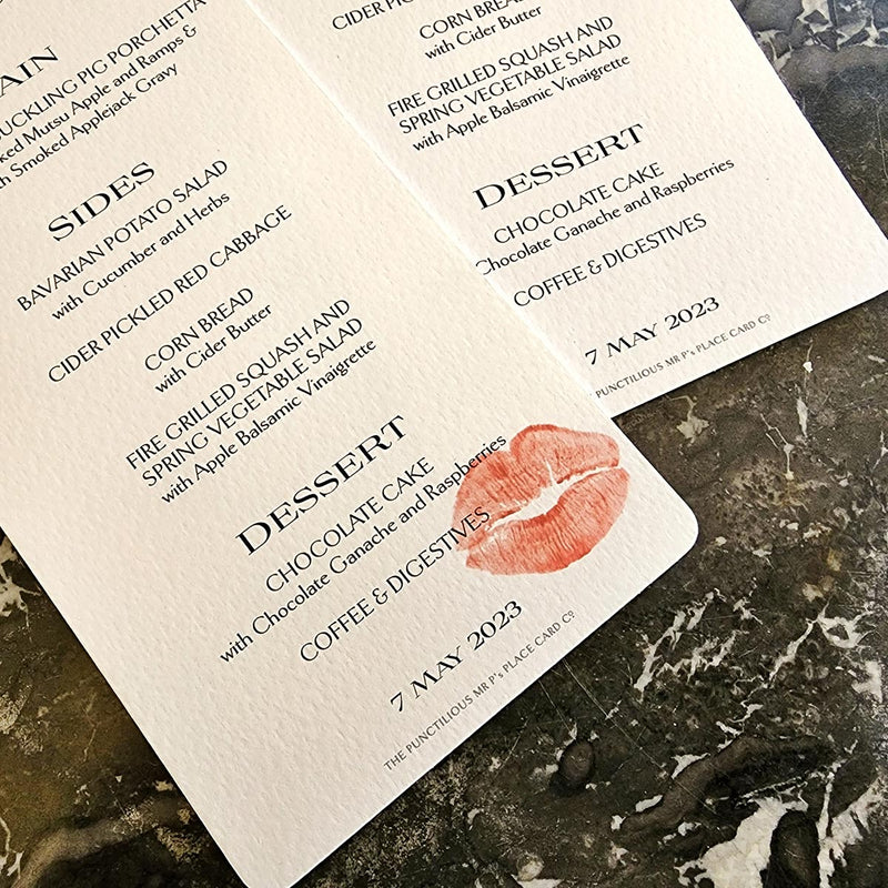 detail of The Punctilious Mr. P's Place Card Co. 'Kisses' Bistro size custom menu of lips on a black marble tabletop