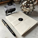 back view of The Punctilious Mr. P's Fine note cards on marble table with bottle of ink and montblanc fountain pen