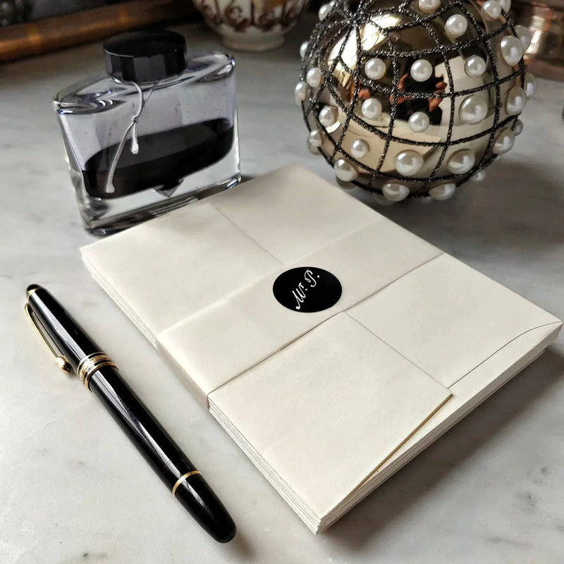back view of The Punctilious Mr. P's Fine note cards on marble table with bottle of ink and montblanc fountain pen
