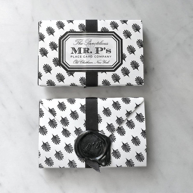 A front and back view of a pack of Mr. P's Place Cards wrapped in their iconic black and white anthemion pattern