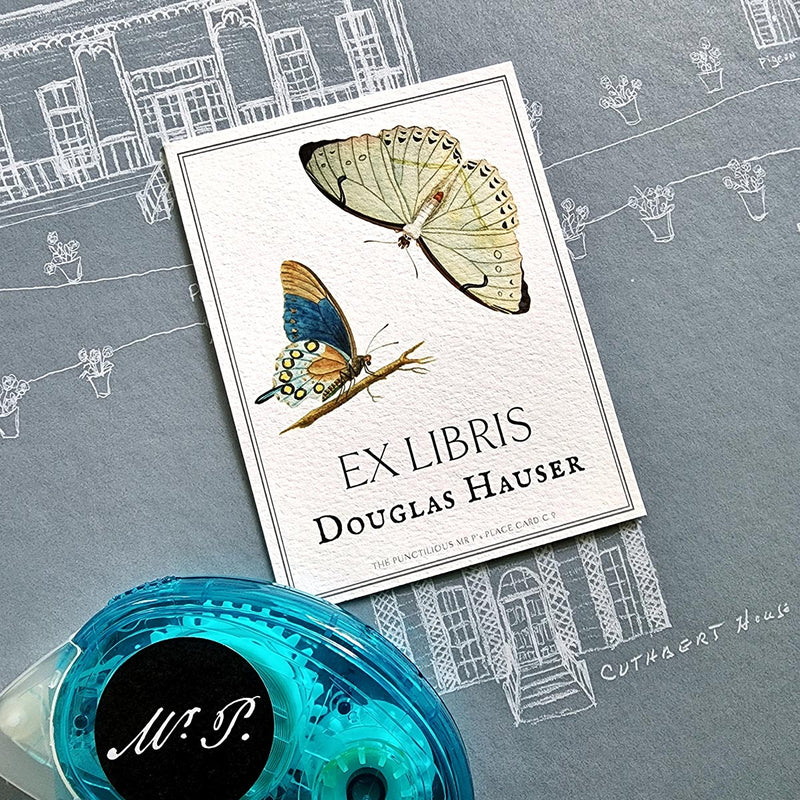The Punctilious Mr. P's Place Card Co. personalized "blue butterflies" motif bookplate in the "Ex Libris" style. with the recommended acid-free removable adhesive roller