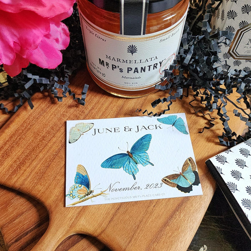 The Punctilious Mr. P's Place Card Co. "Blue Butterflies" Custom Gift Notes on a chinoiserie table with marmalade jam, cutting board and fresh flowers