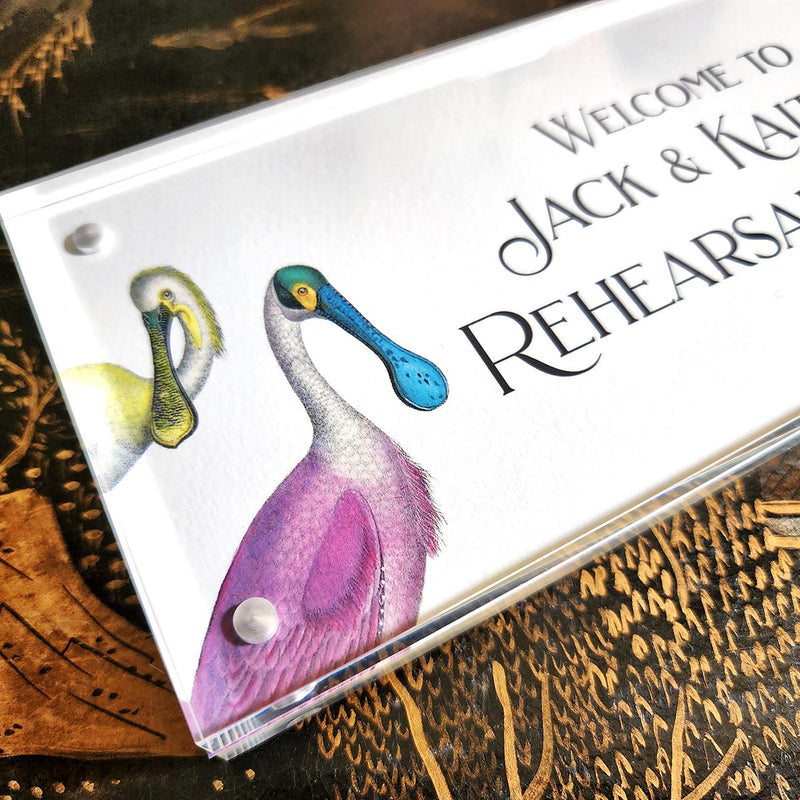 detail of The Punctilious Mr. P's Place Card Co. "Spoonbills Custom Illustrated Signage" in a acrylic book that welcomes wedding guests to a rehearsal dinner