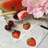 showing all three of The Punctilious Mr. P's Place Card Co. Strawberries Dessert cards on a marble table with peony and a dish with a slice of watermelon and macaroon