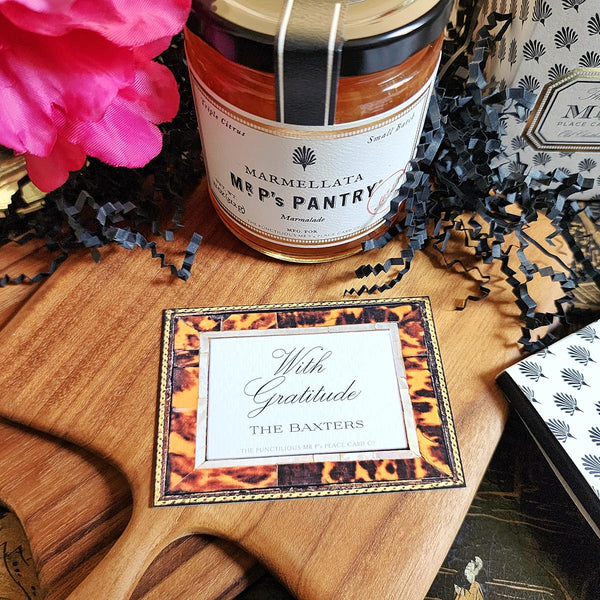 The Punctilious Mr. P's Place Card Co. "Tortoise Shell" Custom Gift Notes on a chinoiserie table with marmalade jam, cutting board and fresh flowers